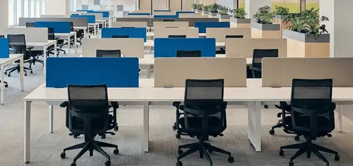 Modern open-plan office space featuring clean workstations, ergonomic chairs, and sanitized carpets provided by professional office cleaning services in Lowell, MA.