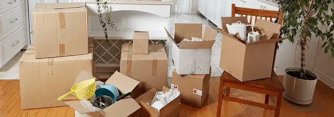 Packed moving boxes and household items in a kitchen before move-out or move-in cleaning, Lowell, MA.